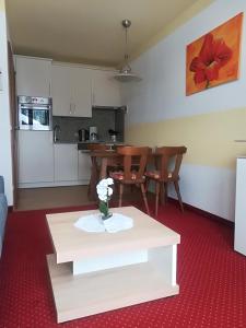 a living room with a table and a kitchen at Ferienwohnung 2 Haus Dörfler in Abtenau