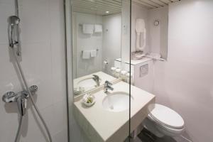 a bathroom with a sink and a toilet and a shower at Hôtel la Residence Du Berry in Versailles