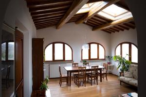 Poggio degli Ulivi في سان كاشانو إن فال دي بيزا: غرفة طعام مع طاولة وكراسي