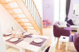 uma sala de estar com uma mesa branca e cadeiras roxas em Sunlight Properties - "Legend " - Bright - Near Promenade des Anglais em Nice