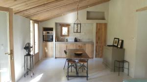 La petite maison في آكس أون بروفانس: مطبخ مع طاولة وكراسي في غرفة