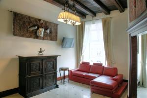 a living room with a red couch and a table at P&J Apartamenty Grodzka in Kraków
