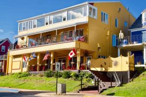 un edificio giallo con persone sui balconi di Rum Runner Inn a Lunenburg