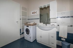a bathroom with a washing machine and a sink at Casa Mari Fronte Lago in Salò