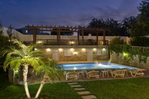 een achtertuin met een zwembad, een tafel en een palmboom bij Villa Amarela in Boliqueime