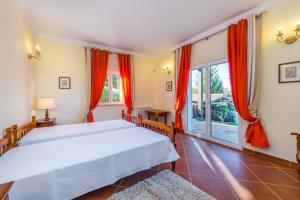 een slaapkamer met een bed en een groot raam bij Villa Amarela in Boliqueime +29 foto's