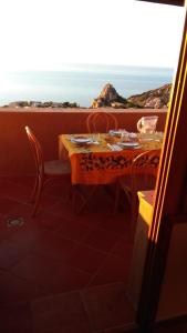 a table and chairs on a balcony with a view of the ocean at Una terrazza in Paradiso in Costa Paradiso