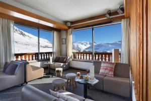 een woonkamer met uitzicht op een besneeuwde berg bij Hôtel Eliova Le Chaix in L'Alpe-d'Huez