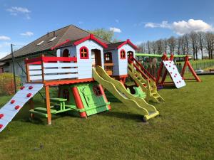 a playground with a slide and a play house at U Sasiadow in Mielenko