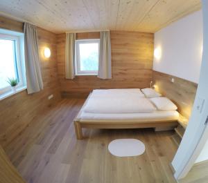 a bedroom with a bed in a wooden room at Ferienbungalow Mountain View Wood in Spital am Pyhrn