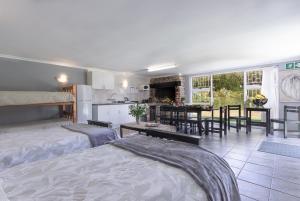 a room with two beds and a kitchen with a table at Kingfisher Hollow in Gordonʼs Bay