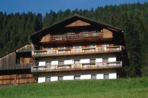 a large building with balconies on top of a hill at Ausserwalderhof in Innervillgraten