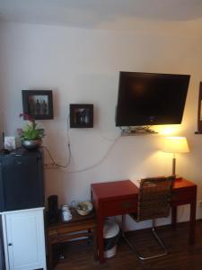een woonkamer met een televisie en een tafel met een lamp bij CityMinis in Düsseldorf