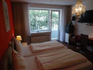 Dos camas en una habitación con ventana. en CityMinis, en Düsseldorf 10 fotos más