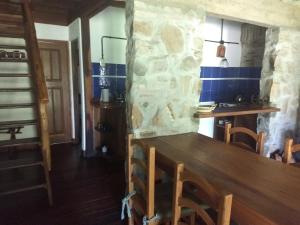 a kitchen with a wooden table and a stone wall at Cabañas del Uru in Colón