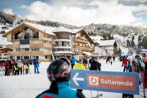 - un groupe de personnes à skis devant un lodge de ski dans l'établissement Hotel Arkadia - "Adults Only", à Corvara in Badia