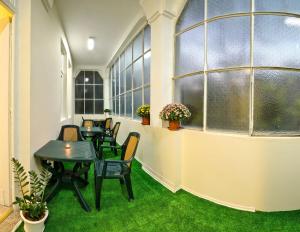 a row of tables and chairs in a room with windows at Guesthouse32 in Sofia