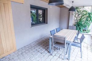 Una mesa y sillas de madera en un patio. en Appartement Gialla, en Porto Vecchio