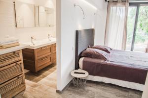 Un dormitorio con una cama, un lavabo y un espejo. en Appartement Gialla, en Porto Vecchio