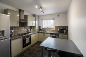 a kitchen with a counter and a table in it at The Mariners in Ayr