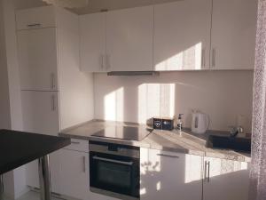 a kitchen with white cabinets and a stove top oven at Apartament AltePost in Żary