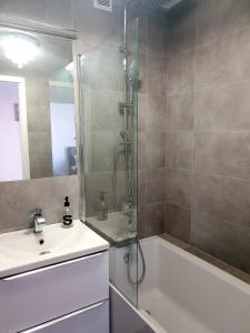 een badkamer met een douche, een wastafel en een bad bij Apartament AltePost in Żary