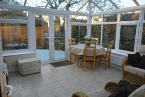 a room with a conservatory with a table and chairs at Sunshine Corner in West Mersea