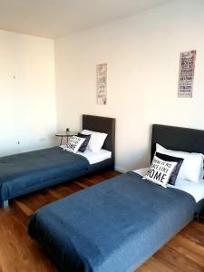 2 łóżka w pokoju z niebieską pościelą i poduszkami w obiekcie Apartament AltePost w mieście Żary
