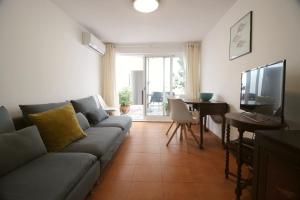 a living room with a couch and a table and a television at Tavira Downtown Calm House in Tavira