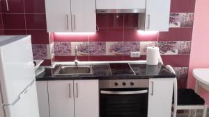 eine Küche mit weißen Schränken und einer Spüle in der Unterkunft Lovely 1-bedroom apartment with a big terrace, Las Americas, Tenerife in Arona