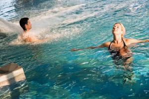 a man and a woman in the water at B’O Resort & Spa in Bagnoles de l'Orne