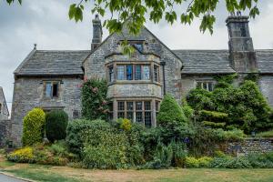 une ancienne maison en pierre avec un jardin en face de celle-ci dans l'établissement YHA Hartington Hall, à Hartington