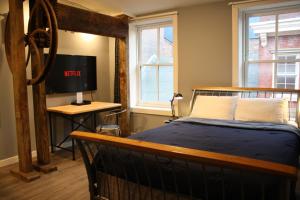 a bedroom with a bed and a desk with a television at Apple Hostels of Philadelphia in Philadelphia
