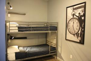 a room with bunk beds and a clock on the wall at Apple Hostels of Philadelphia in Philadelphia