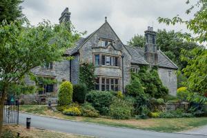 an old stone house on the side of a road at YHA Hartington Hall in Hartington