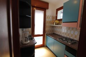 een keuken met blauwe kasten en een aanrecht bij Villa Agavi in Bibione
