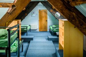 Pokój na poddaszu z łóżkami piętrowymi i korytarzem w obiekcie YHA Hartington Hall w mieście Hartington