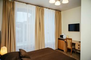 um quarto de hotel com uma cama, uma secretária e uma janela em Апартаменты Sampo em Vyborg
