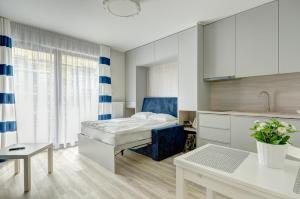 a small bedroom with a bed and a kitchen at Dom & House - Apartments Nowa Motława in Gdańsk