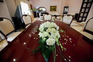 a table with a bouquet of white flowers on it at Hotel Bevanda in Mostar