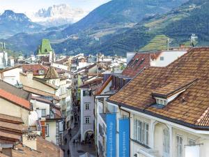 una ciudad con edificios y montañas en el fondo en City Charme Apartments, en Bolzano