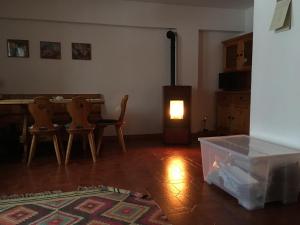 uma sala de estar com uma mesa e cadeiras e um fogão em La Maisonnette em Pré-Saint-Didier