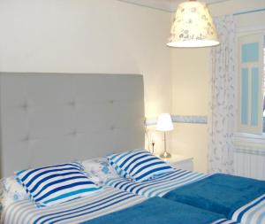 two beds with blue and white striped pillows in a bedroom at CasasMontseny in Arbúcies
