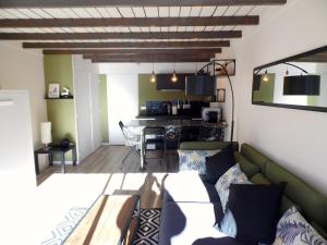 ein Wohnzimmer mit einem grünen Sofa und einem Tisch in der Unterkunft Pra Loup Appart'hotel in Pra-Loup