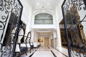 a hallway with black chairs and a chandelier at Villa De Khaosan by Chillax in Bangkok