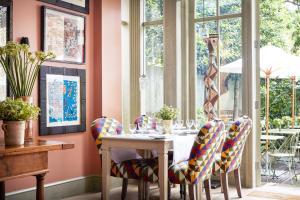 a dining room with a table with chairs and a window at Number Sixteen, Firmdale Hotels in London