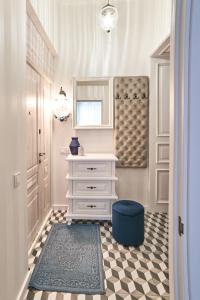 a bathroom with a white dresser and a blue stool at LUX APARTAMENT на Левицького in Lviv