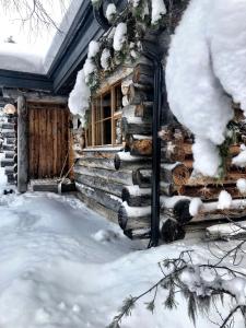 a log cabin with a window covered in snow at Ruka Chalet Charmant Oliver in Ruka