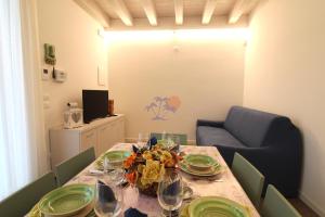 una sala da pranzo con tavolo e piatti verdi di Appartamenti Acquadolce a Peschiera del Garda
