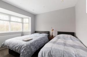 a bedroom with two beds and a window at Monyhull Homestay - near City centre Kingsheath NIA NEC BHX in Birmingham